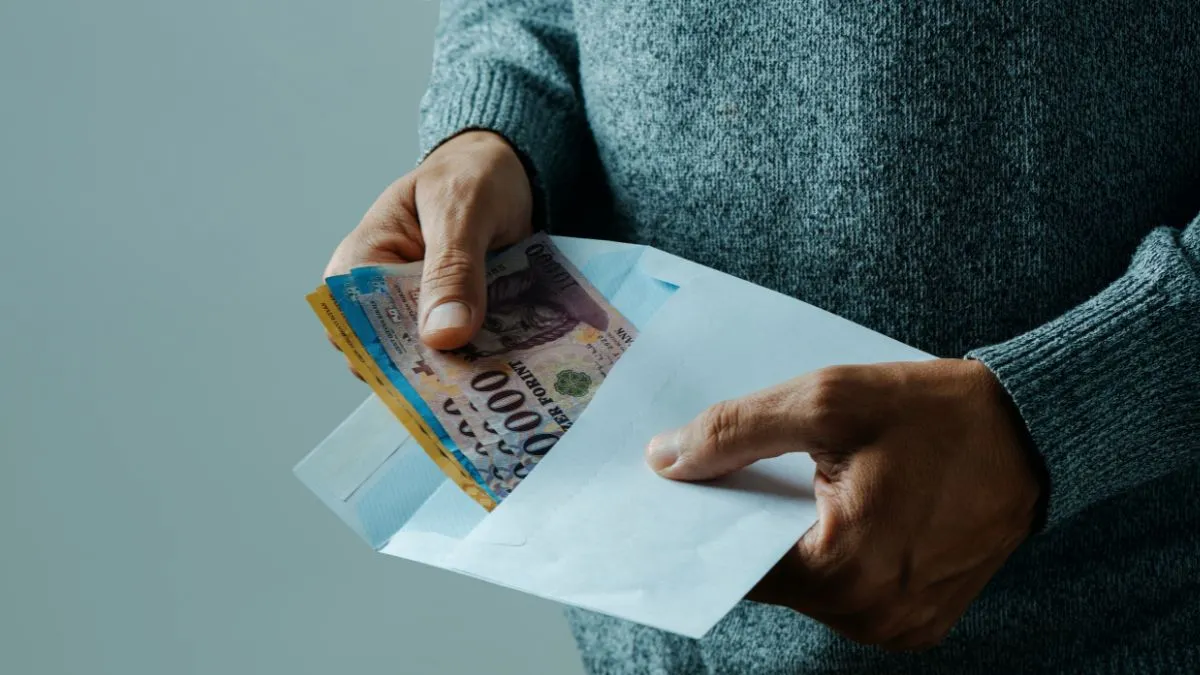 Márciusi családtámogatási utalások érkezését jelképező boríték pénzzel