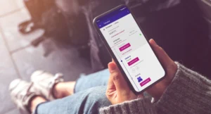 Női kéz okostelefont tart, a Wizz Air alkalmazásban a becsekkolás képernyője látható.